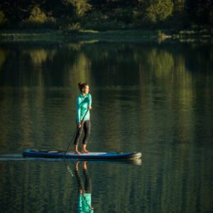 Female paddle boarder enjoying quiet morning on Green lake.